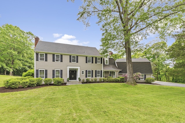 47 Ridgecrest Rd, Stamford, CT 06903 - colonial-style house featuring a chimney, a front lawn, roof with shingles, and asphalt driveway