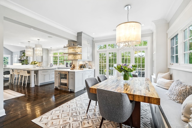 975 Flintlock Rd, Fairfield, CT 06890 - dining area with a chandelier, wine cooler, dark wood-style floors, ornamental molding, and recessed lighting