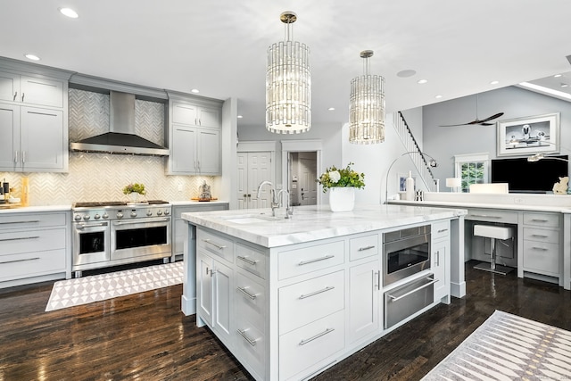 975 Flintlock Rd, Fairfield, CT 06890 - kitchen with stainless steel appliances, a warming drawer, a sink, wall chimney exhaust hood, and gray cabinetry