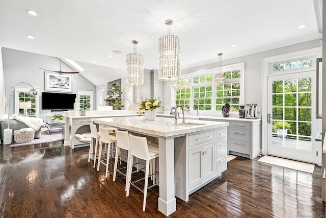 975 Flintlock Rd, Fairfield, CT 06890 - kitchen featuring a sink, a center island with sink, dark wood finished floors, a kitchen breakfast bar, and open floor plan
