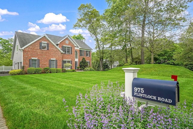 975 Flintlock Rd, Fairfield, CT 06890 - colonial house with brick siding, a front lawn, and a shingled roof