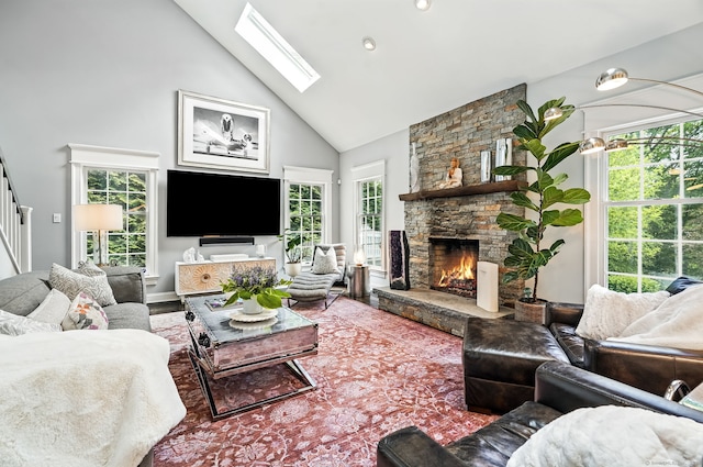 975 Flintlock Rd, Fairfield, CT 06890 - living area featuring high vaulted ceiling, healthy amount of natural light, a stone fireplace, a skylight, and wood finished floors