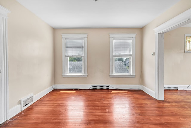 174 Franklin Ave, Stratford, CT 06614 - empty room with healthy amount of natural light, wood-type flooring, and baseboards