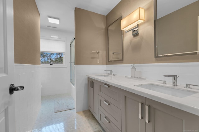 14 The Mews, Westport, CT 06880 - full bathroom with tile walls, double vanity, toilet, a wainscoted wall, and enclosed tub / shower combo