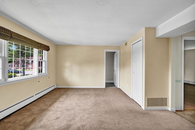 4 Loveland Hill Rd Unit F2, Vernon, CT 06066 - empty room with a baseboard heating unit, carpet flooring, baseboards, and a textured ceiling