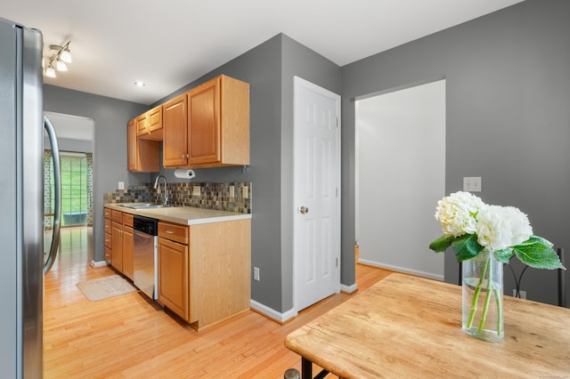 19 Hawthorne Dr Unit 124, New London, CT 06320 - kitchen with appliances with stainless steel finishes, light wood-style flooring, light countertops, a sink, and backsplash
