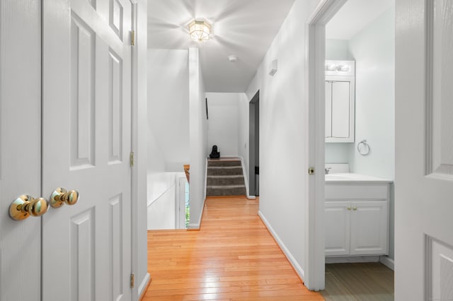 19 Hawthorne Dr Unit 124, New London, CT 06320 - corridor with light wood-type flooring, a sink, baseboards, and stairs