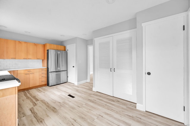 170 Heritage Vlg Unit B, Southbury, CT 06488 - kitchen featuring freestanding refrigerator, light countertops, light wood-style flooring, tasteful backsplash, and baseboards