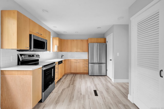 170 Heritage Vlg Unit B, Southbury, CT 06488 - kitchen with stainless steel appliances, a sink, light brown cabinets, light countertops, and light wood-style floors