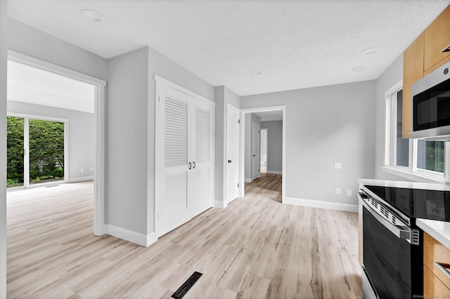 170 Heritage Vlg Unit B, Southbury, CT 06488 - kitchen featuring light wood finished floors, appliances with stainless steel finishes, baseboards, and light countertops