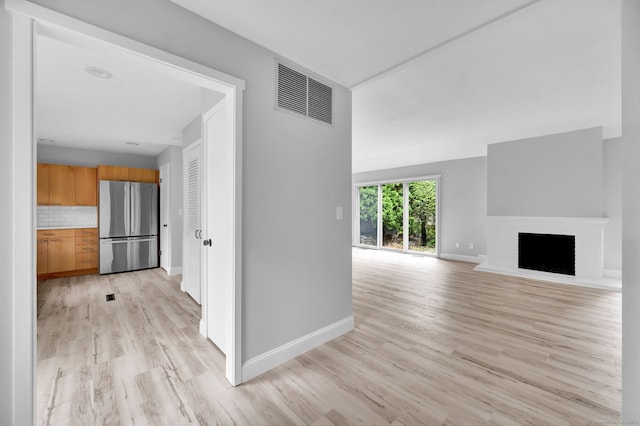 170 Heritage Vlg Unit B, Southbury, CT 06488 - unfurnished living room with light wood finished floors, baseboards, and a fireplace with raised hearth