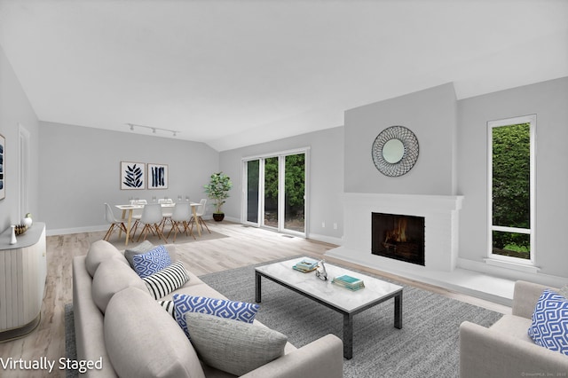 170 Heritage Vlg Unit B, Southbury, CT 06488 - living area featuring wood finished floors, a lit fireplace, baseboards, track lighting, and vaulted ceiling