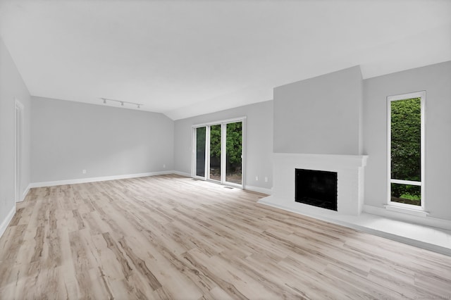 170 Heritage Vlg Unit B, Southbury, CT 06488 - unfurnished living room with wood finished floors, plenty of natural light, a fireplace, rail lighting, and lofted ceiling