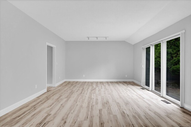 170 Heritage Vlg Unit B, Southbury, CT 06488 - empty room featuring light wood finished floors, track lighting, vaulted ceiling, and baseboards