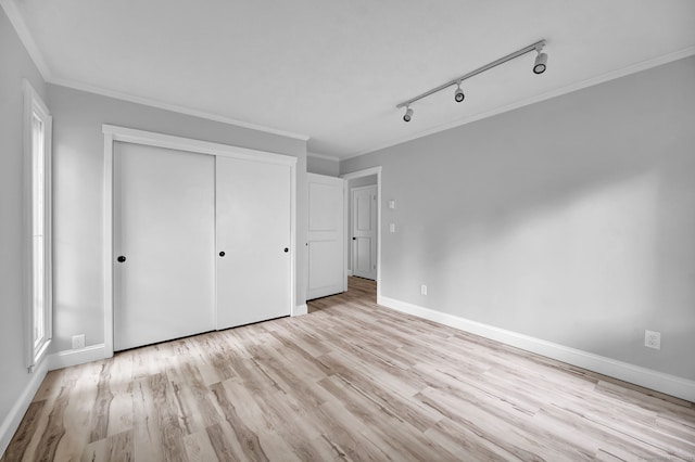 170 Heritage Vlg Unit B, Southbury, CT 06488 - unfurnished bedroom featuring baseboards, light wood-style floors, crown molding, a closet, and rail lighting