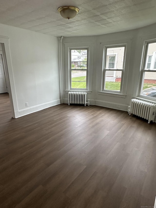 47 Holl St, Manchester, CT 06040 - spare room with radiator, dark wood finished floors, and baseboards