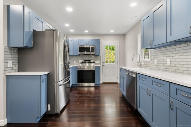 56 Uncas Ave, New London, CT 06320 - kitchen featuring appliances with stainless steel finishes, blue cabinets, backsplash, a sink, and dark wood finished floors