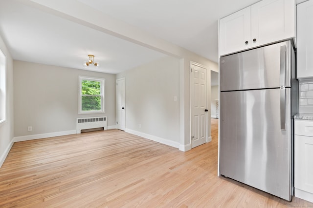 1357 Slater Rd, New Britain, CT 06053 - kitchen with freestanding refrigerator, radiator, light wood-style flooring, white cabinetry, and baseboards