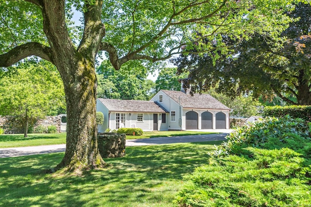 264 Taugwonk Rd, Stonington, CT 06378 - view of front of house featuring driveway, a front yard, an attached garage, and a chimney