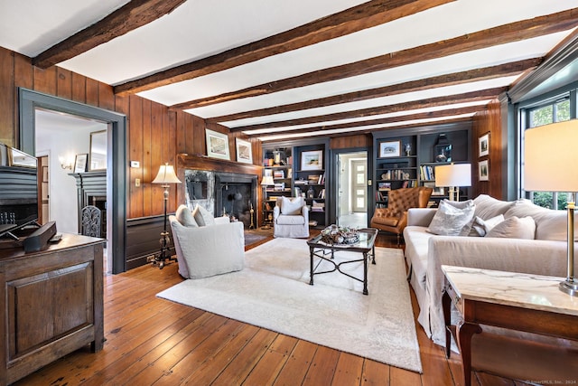 264 Taugwonk Rd, Stonington, CT 06378 - living room featuring a fireplace, wood walls, hardwood / wood-style floors, and beam ceiling