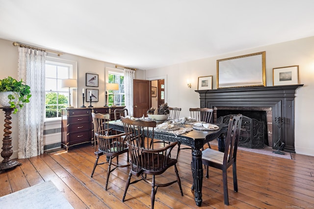 264 Taugwonk Rd, Stonington, CT 06378 - dining space featuring a fireplace with flush hearth and wood-type flooring