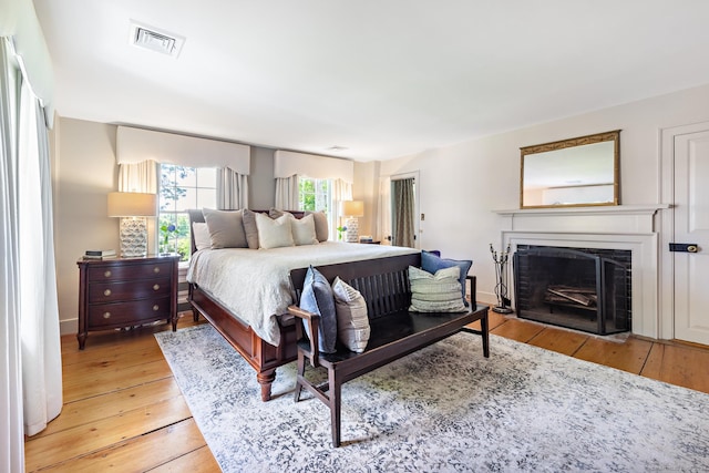 264 Taugwonk Rd, Stonington, CT 06378 - bedroom with a fireplace with flush hearth and light wood-type flooring