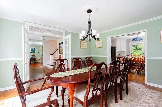 12 Fawn Ridge Dr, Brookfield, CT 06804 - dining room featuring light wood finished floors, a chandelier, ornamental molding, stairs, and baseboards