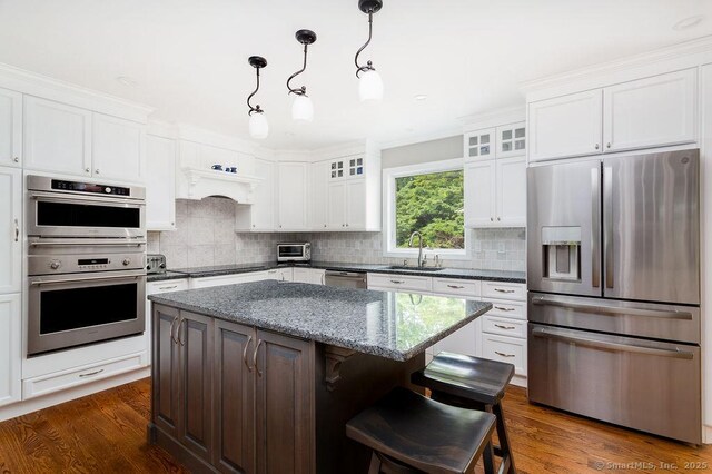 12 Fawn Ridge Dr, Brookfield, CT 06804 - kitchen featuring stainless steel appliances, backsplash, a kitchen island, white cabinetry, and crown molding