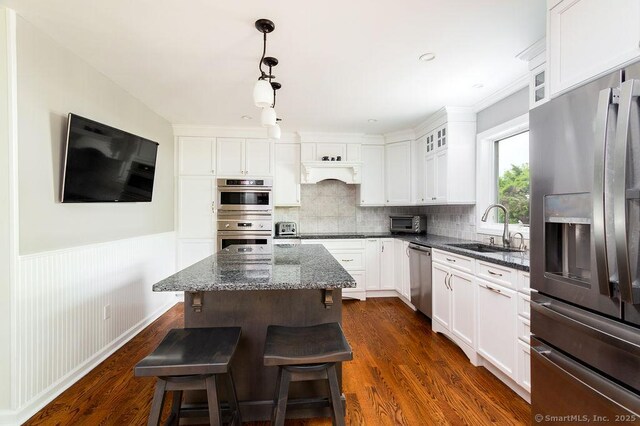 12 Fawn Ridge Dr, Brookfield, CT 06804 - kitchen featuring stainless steel appliances, a sink, dark stone counters, a center island, and white cabinets