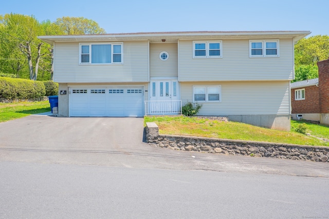 188 Judith Ln, Waterbury, CT 06704 - view of front of house featuring a garage, concrete driveway, and a front yard