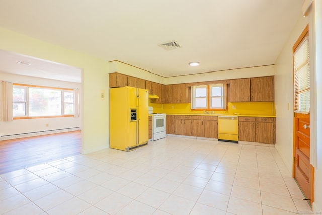 188 Judith Ln, Waterbury, CT 06704 - kitchen with white appliances, a baseboard heating unit, light countertops, and plenty of natural light