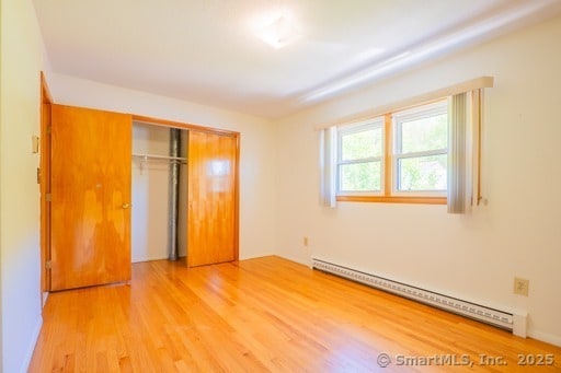 188 Judith Ln, Waterbury, CT 06704 - unfurnished bedroom with a baseboard radiator, light wood finished floors, and a closet