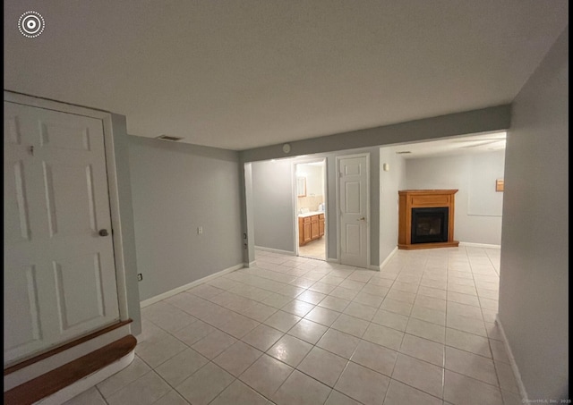 188 Judith Ln, Waterbury, CT 06704 - empty room featuring a fireplace, light tile patterned floors, and baseboards