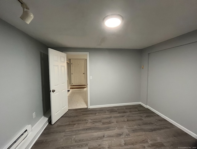 188 Judith Ln, Waterbury, CT 06704 - unfurnished bedroom with a baseboard heating unit, dark wood finished floors, and baseboards