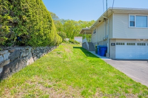 188 Judith Ln, Waterbury, CT 06704 - view of home's exterior with asphalt driveway, a garage, and a lawn