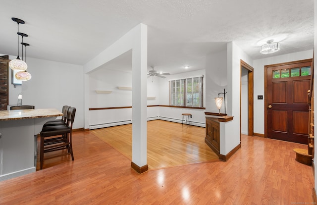 80 Farmstead Ln, Windsor, CT 06095 - kitchen featuring a kitchen bar, light wood-style floors, baseboards, baseboard heating, and decorative light fixtures