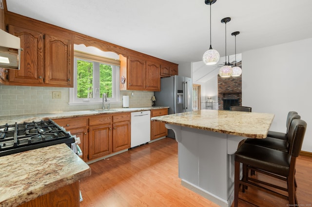 80 Farmstead Ln, Windsor, CT 06095 - kitchen with appliances with stainless steel finishes, a sink, light wood-style floors, backsplash, and a fireplace