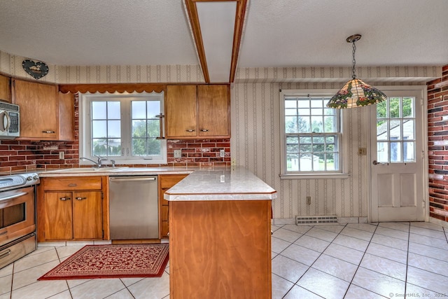 423 Baldwin Ave, Meriden, CT 06450 - kitchen featuring appliances with stainless steel finishes, brown cabinetry, a peninsula, wallpapered walls, and a textured ceiling