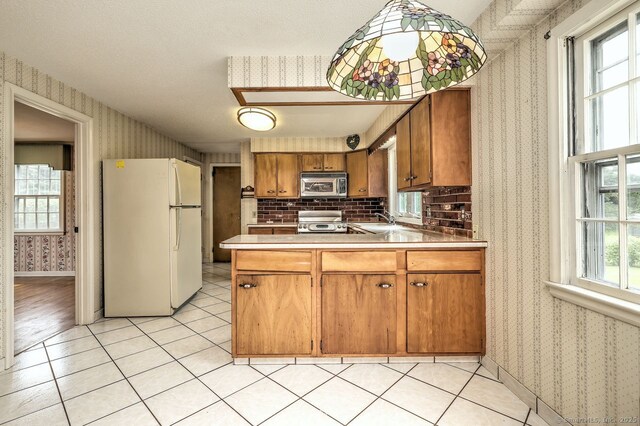 423 Baldwin Ave, Meriden, CT 06450 - kitchen featuring freestanding refrigerator, stainless steel microwave, wallpapered walls, stove, and a sink