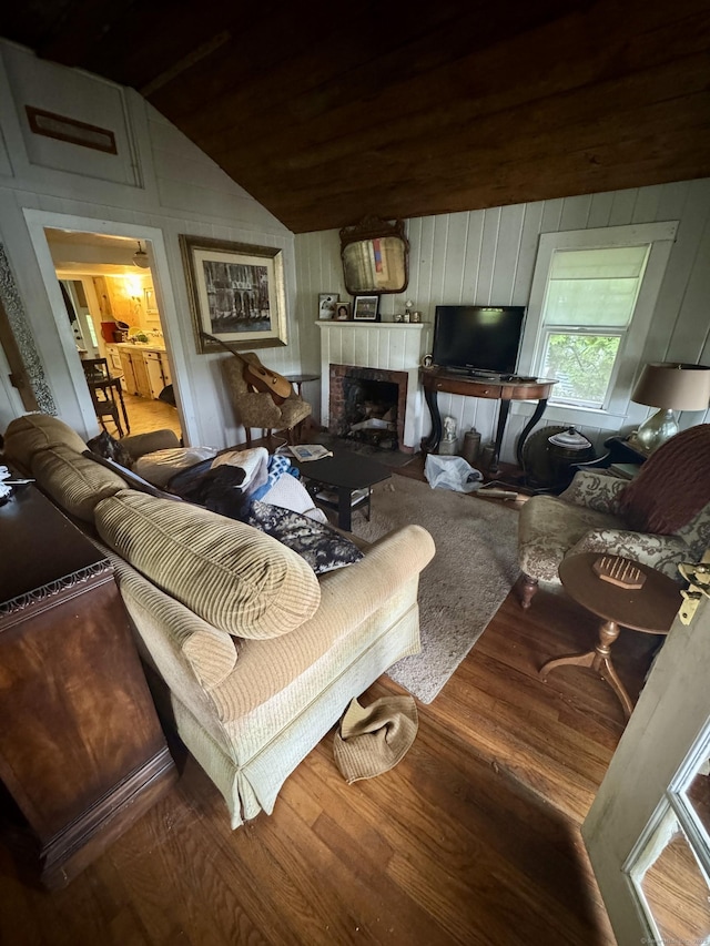 343 W Wakefield Blvd, Winchester, CT 06098 - living room featuring wood finished floors, a tile fireplace, lofted ceiling, and wooden walls