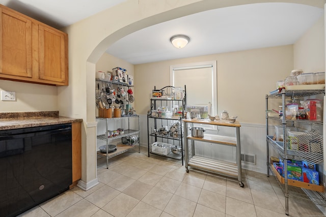 124 Jordan Ln, Wethersfield, CT 06109 - kitchen with arched walkways, light tile patterned flooring, a wainscoted wall, and black dishwasher