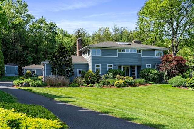 94 Southpond Rd, Glastonbury, CT 06073 - shingle-style home featuring a chimney, a front yard, solar panels, and roof with shingles