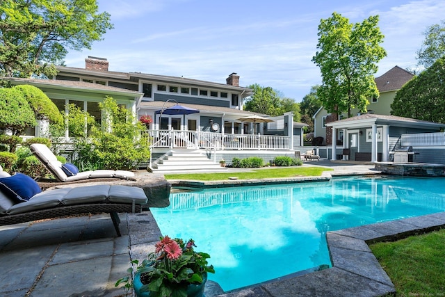 94 Southpond Rd, Glastonbury, CT 06073 - back of property featuring an outdoor structure, a chimney, an outdoor pool, and a deck