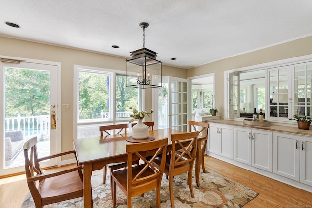 94 Southpond Rd, Glastonbury, CT 06073 - dining space featuring light wood-style floors, plenty of natural light, a chandelier, and ornamental molding