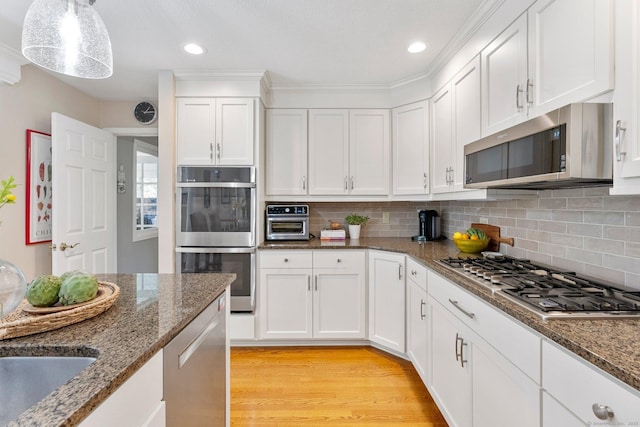94 Southpond Rd, Glastonbury, CT 06073 - kitchen featuring appliances with stainless steel finishes, white cabinets, backsplash, light wood-type flooring, and dark stone counters