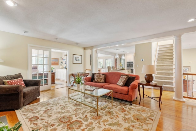 94 Southpond Rd, Glastonbury, CT 06073 - living room featuring light wood-style floors, healthy amount of natural light, decorative columns, a textured ceiling, and recessed lighting