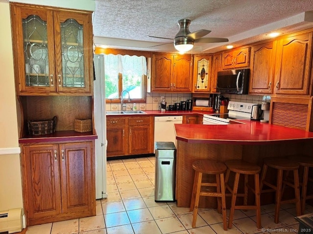 30 Cedar Ave, Wolcott, CT 06716 - kitchen with white appliances, a sink, baseboard heating, tasteful backsplash, and brown cabinets