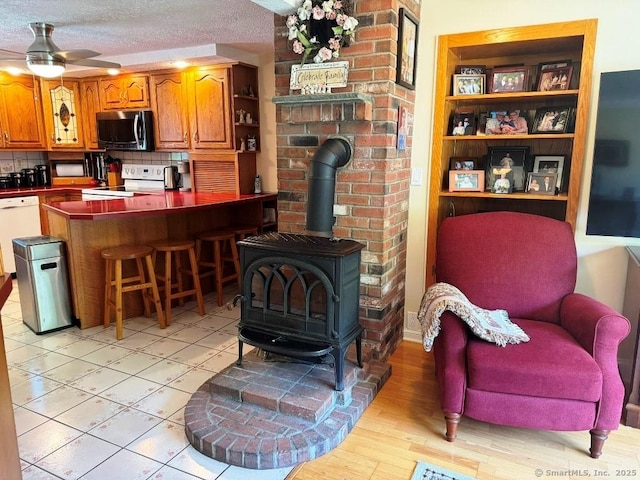 30 Cedar Ave, Wolcott, CT 06716 - living area featuring a wood stove, a ceiling fan, and light wood-type flooring
