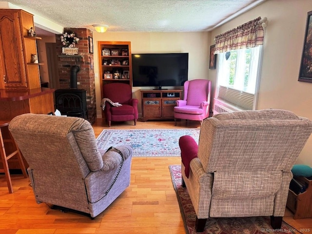 30 Cedar Ave, Wolcott, CT 06716 - living area with a wood stove, a textured ceiling, light wood-style floors, and built in shelves