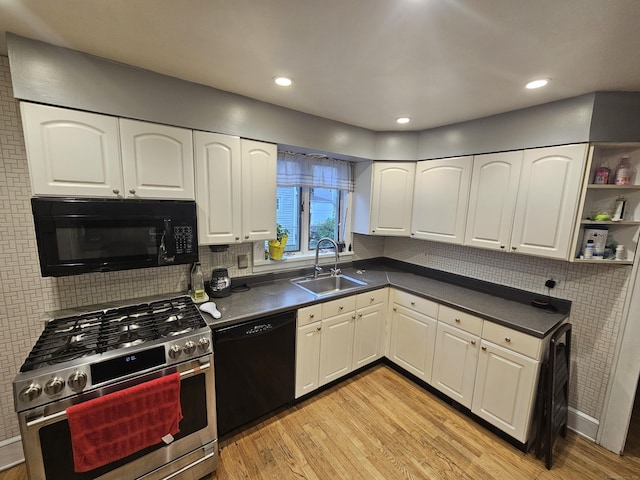 58 Waverly Pl, Bridgeport, CT 06610 - kitchen with black appliances, a sink, dark countertops, light wood-style flooring, and white cabinets